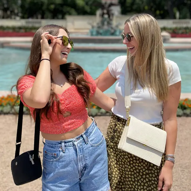 two young women standing by a pond